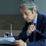 Trabajador revisando documentos con expresión seria, simbolizando una reclamación de salarios con ayuda de un abogado laboralista.