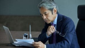 Trabajador revisando documentos con expresión seria, simbolizando una reclamación de salarios con ayuda de un abogado laboralista.