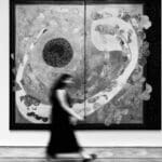 Artista en una galería de arte performativo interactuando con el público durante una acción en vivo en un espacio contemporáneo de Madrid