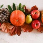 Composición otoñal de calabazas, manzanas, peras y hojas secas que ilustra alimentos de temporada ricos en vitaminas y antioxidantes para reforzar el sistema inmunológico.