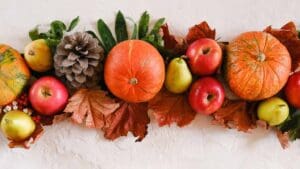 Composición otoñal de calabazas, manzanas, peras y hojas secas que ilustra alimentos de temporada ricos en vitaminas y antioxidantes para reforzar el sistema inmunológico.