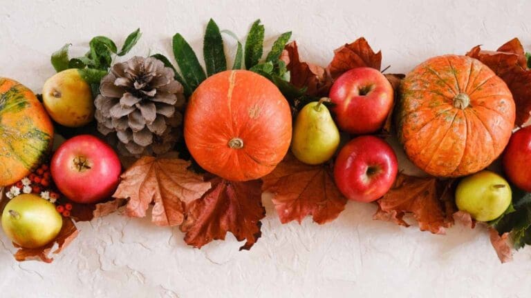 Composición otoñal de calabazas, manzanas, peras y hojas secas que ilustra alimentos de temporada ricos en vitaminas y antioxidantes para reforzar el sistema inmunológico.
