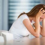 Ilustración de mujer joven con ansiedad por no tener su móvil, representando la nomofobia y la necesidad de terapia psicológica”