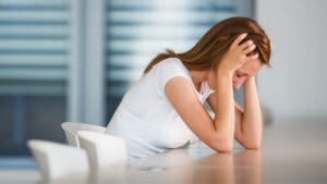 Ilustración de mujer joven con ansiedad por no tener su móvil, representando la nomofobia y la necesidad de terapia psicológica”