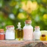 Jabones naturales artesanales y productos de cosmética expuestos en un entorno vegetal, rodeados de hojas y flores, en armonía con la naturaleza.