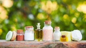 Jabones naturales artesanales y productos de cosmética expuestos en un entorno vegetal, rodeados de hojas y flores, en armonía con la naturaleza.