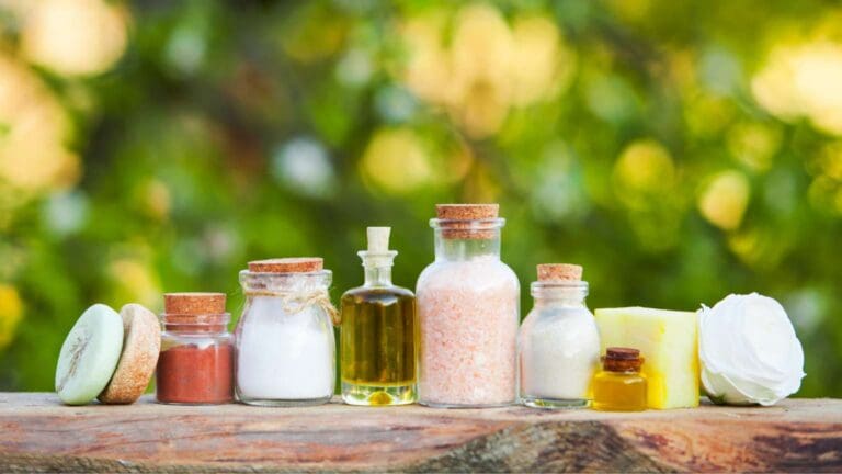 Jabones naturales artesanales y productos de cosmética expuestos en un entorno vegetal, rodeados de hojas y flores, en armonía con la naturaleza.
