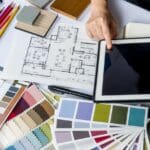 Planificación creativa de reformas integrales con moodboards, planos y tecnología sobre la mesa.