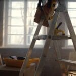 Interior de una casa en reforma casa con escalera sin terminar, paredes abiertas y materiales de obra visibles.