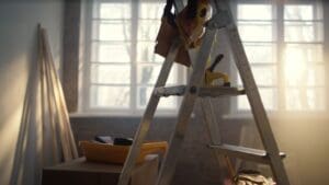 Interior de una casa en reforma casa con escalera sin terminar, paredes abiertas y materiales de obra visibles.