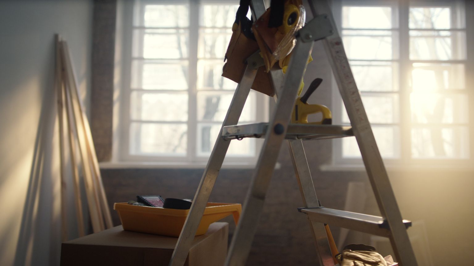 Interior de una casa en reforma casa con escalera sin terminar, paredes abiertas y materiales de obra visibles.