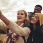 Grupo de amigos disfrutando juntos en una casa rural y tomando una foto durante su viaje