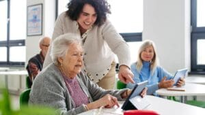 Mujer mayor acompañada por una profesional en una sesión de estimulación cognitiva para detectar señales tempranas de deterioro