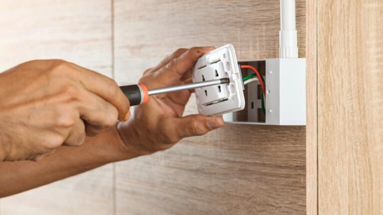 Instalaciones eléctricas seguras con electricista ajustando un enchufe de pared