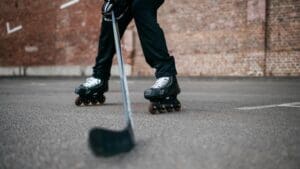Jugador practicando hockey sobre patines con stick y patines en pista urbana