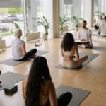Grupo diverso de personas practicando yoga en un estudio en Barcelona, en un ambiente relajado que representa una alternativa al gimnasio tradicional.