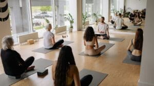 Grupo diverso de personas practicando yoga en un estudio en Barcelona, en un ambiente relajado que representa una alternativa al gimnasio tradicional.