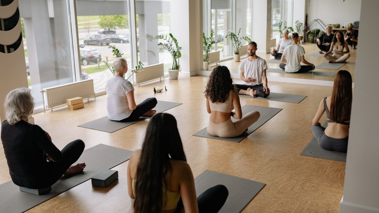 Grupo diverso de personas practicando yoga en un estudio en Barcelona, en un ambiente relajado que representa una alternativa al gimnasio tradicional.