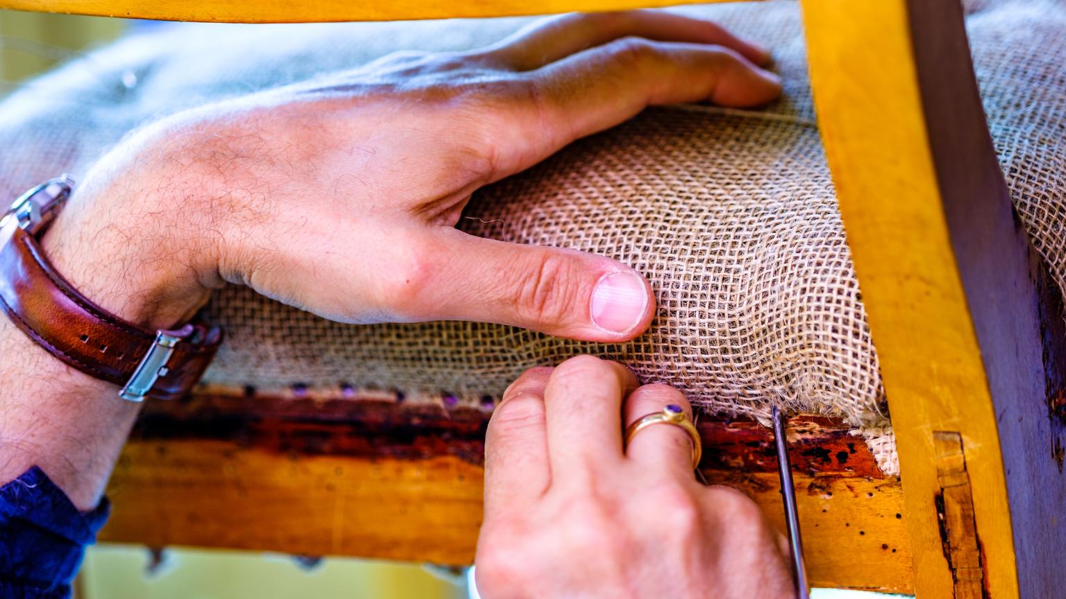 Trabajo artesanal de tapiceros en Madrid restaurando una silla con técnicas tradicionales