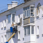 Trabajadores realizando mantenimiento de edificios en una fachada urbana