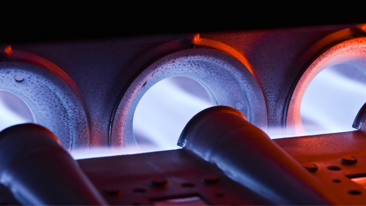 Vista lateral de quemadores de biomasa funcionando con pellets en entorno industrial