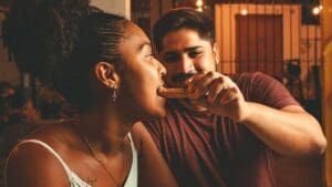 Pareja compartiendo churros con chocolate en Barcelona, disfrutando de un momento emocional y tradicional en un entorno acogedor.