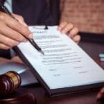 Abogado en Gran Canaria mostrando un documento para firmar, símbolo de confianza, profesionalidad y asesoría jurídica personalizada.
