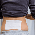 Persona usando parches musculares naturales para relajar los hombros después de entrenar.