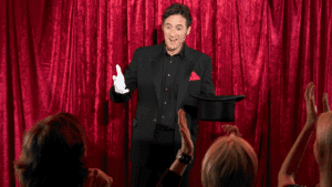 Entretenimiento para eventos con un mago actuando frente a invitados sonrientes.