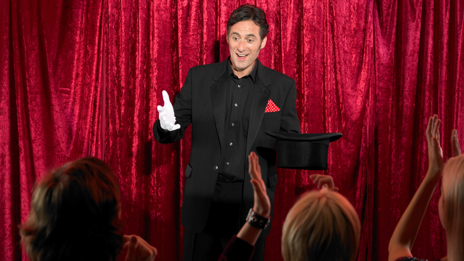 Entretenimiento para eventos con un mago actuando frente a invitados sonrientes.