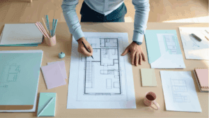 Mesa con planos y materiales usados en servicios de arquitectura.