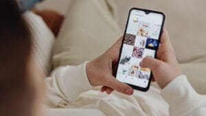 Persona usando una app de comida a domicilio desde casa para pedir su plato favorito fácilmente desde el móvil