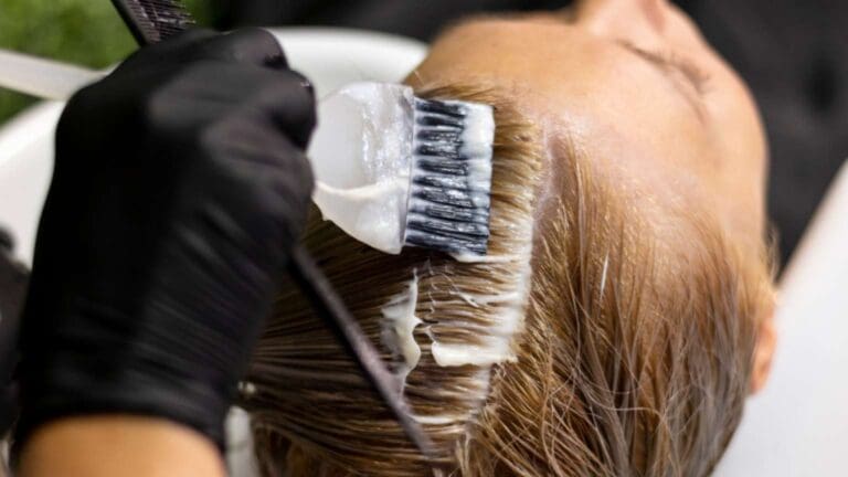 Peluquera profesional en salón de belleza en Madrid aplicando tratamiento natural a clienta con cabello sano y brillante