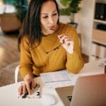 Mujer revisando gráficos y analizando información como parte de una consultoría de negocios