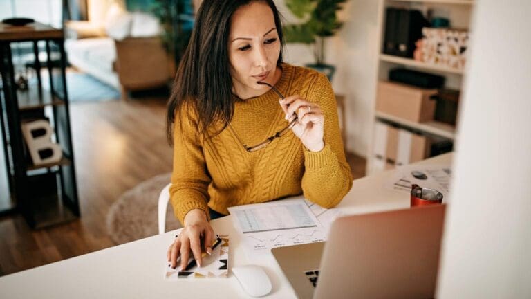 Mujer revisando gráficos y analizando información como parte de una consultoría de negocios