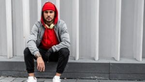Joven con ropa urbana cómoda combinando sudadera oversize y joggers en entorno urbano