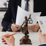 Escena de peritaje jurídico en proceso de divorcio con abogados y documentos legales sobre la mesa.