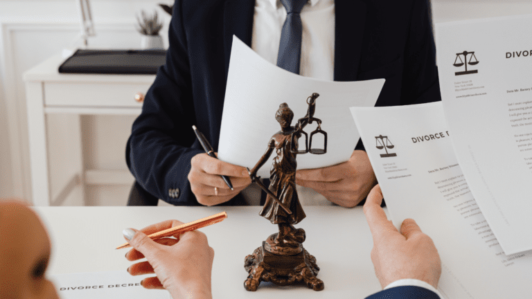 Escena de peritaje jurídico en proceso de divorcio con abogados y documentos legales sobre la mesa.