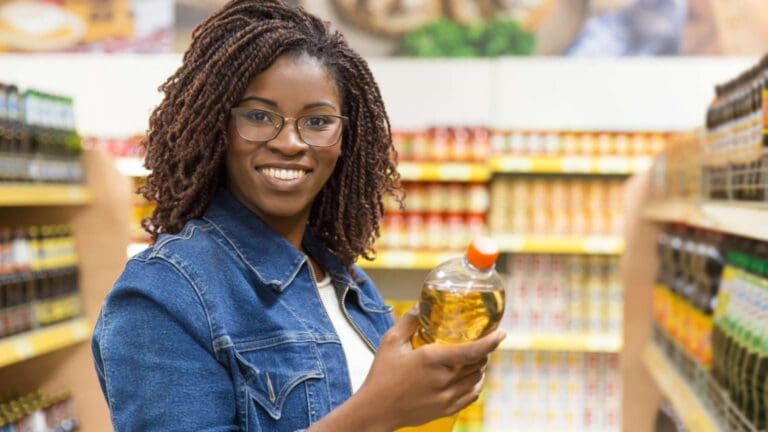 Estante de tienda con productos africanos y latinos, como salsas, harinas, especias y legumbres, con etiquetas coloridas y variedad cultural.