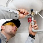 Fontanero realizando una reparación profesional en una instalación de fontanería doméstica