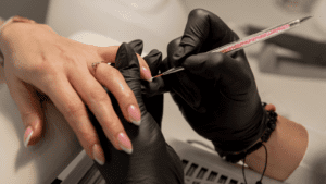 Manicura profesional con uñas almendradas en salón de belleza.