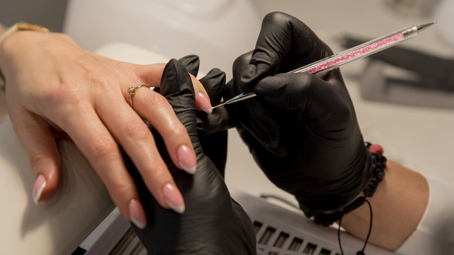Manicura profesional con uñas almendradas en salón de belleza.