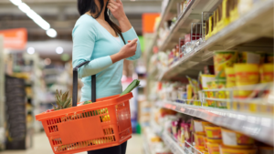 Persona comprando productos de gran consumo en un supermercado.