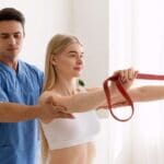 Sesión de fisioterapia en una clínica moderna con ambiente tranquilo, fisioterapeuta profesional atendiendo a paciente, enfoque en bienestar y cuidado integral.