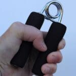 Hombre realizando ejercicios de rehabilitación de mano en casa tras una lesión