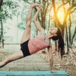 Persona haciendo yoga para principiantes en esterilla sobre césped en entorno natural, ideal para entrenamientos suaves