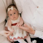 Recién nacido con ropa orgánica en tonos naturales.