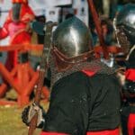 Personas disfrutando un espectáculo inmersivo medieval con combates, música en vivo y ambientación histórica en un evento temático en España