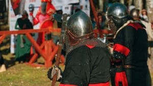 Personas disfrutando un espectáculo inmersivo medieval con combates, música en vivo y ambientación histórica en un evento temático en España