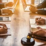 Equipo de abogados brindando asesoría legal a empresarios para evitar sanciones y cumplir con las normativas legales vigentes